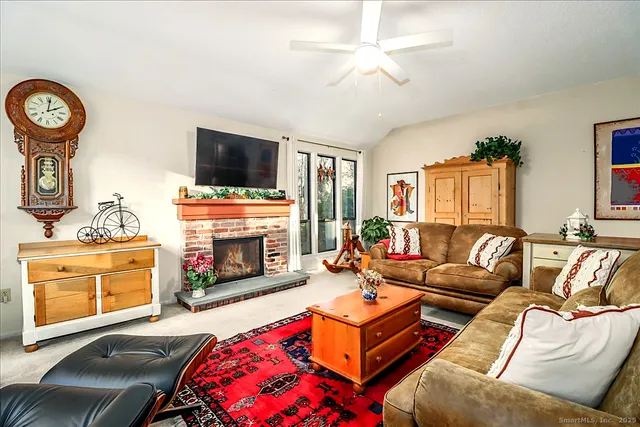 a living room with furniture a flat screen tv and a fireplace