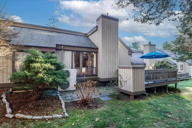 a patio with wooden floor a yard a table and chairs