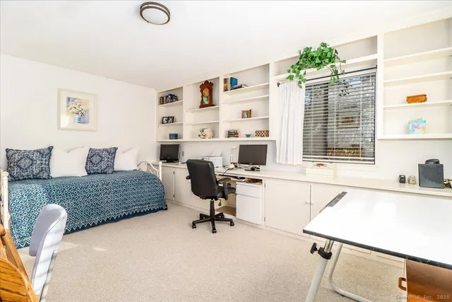 a view of a workspace with furniture and a window