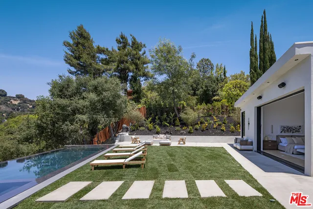 a view of a pool with two chairs and a table