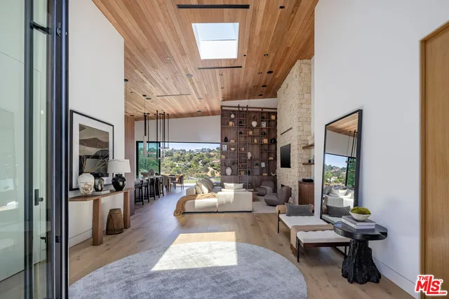 a living room with furniture fireplace and a large window