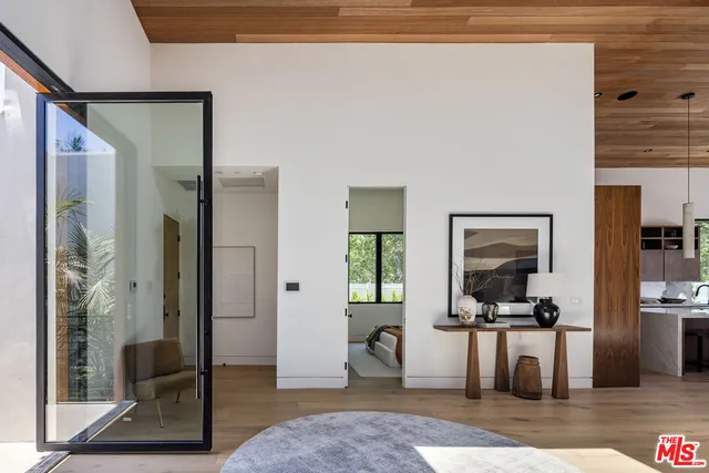 a living room with furniture a rug and a view of kitchen