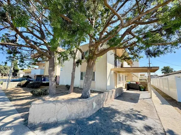 a view of a house with backyard and sitting area