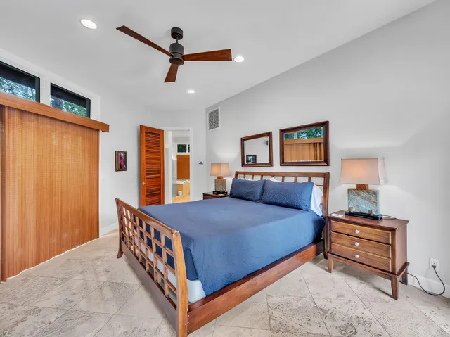 a bedroom with a bed next to a window