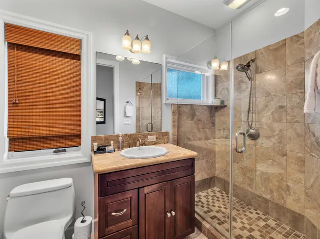 a bathroom with a sink a toilet and shower