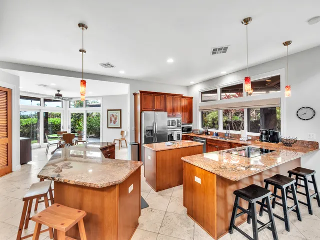 a dining table with chairs kitchen view kitchen counter and a large window