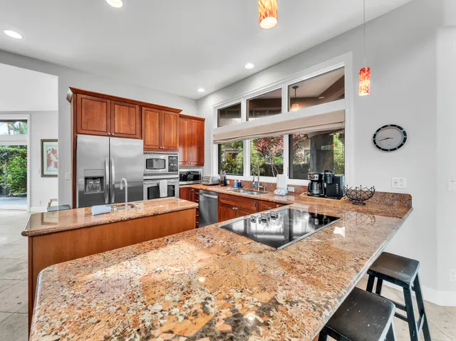 a large kitchen with kitchen island a large window in it