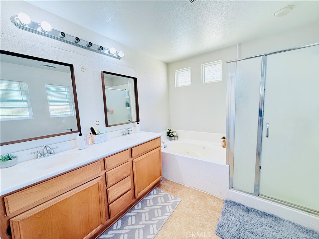 1652 Apollo Way Beaumont, CA 92223 - Photo 16 of 25 a bathroom with a tub sink and mirror