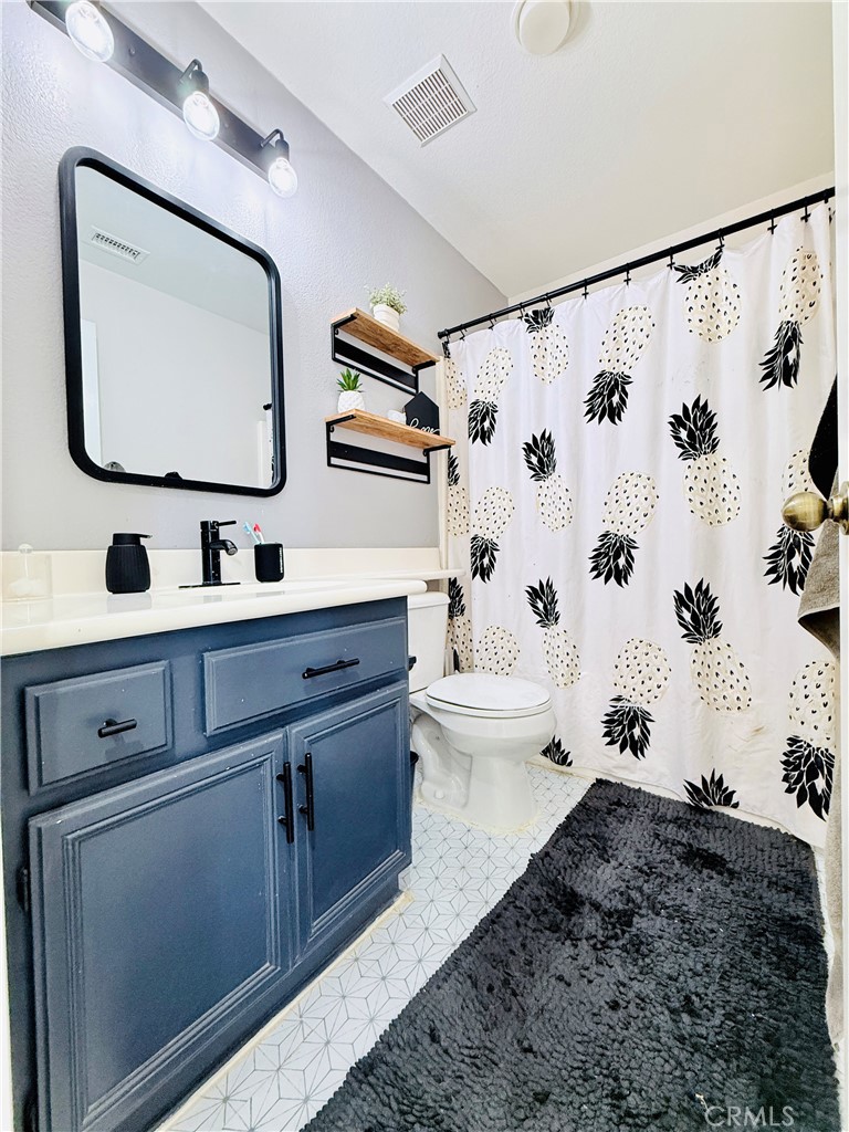 1652 Apollo Way Beaumont, CA 92223 - Photo 18 of 25 a bathroom with a toilet sink and mirror