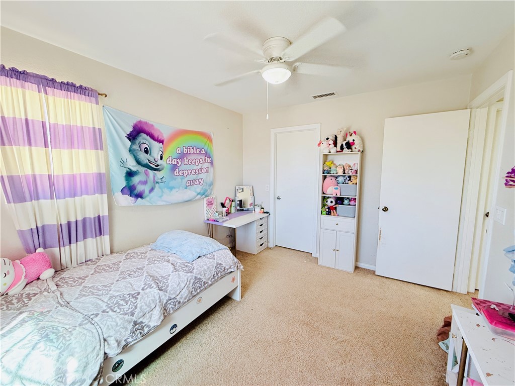 1652 Apollo Way Beaumont, CA 92223 - Photo 20 of 25 a bedroom with a bed and a painting on the wall