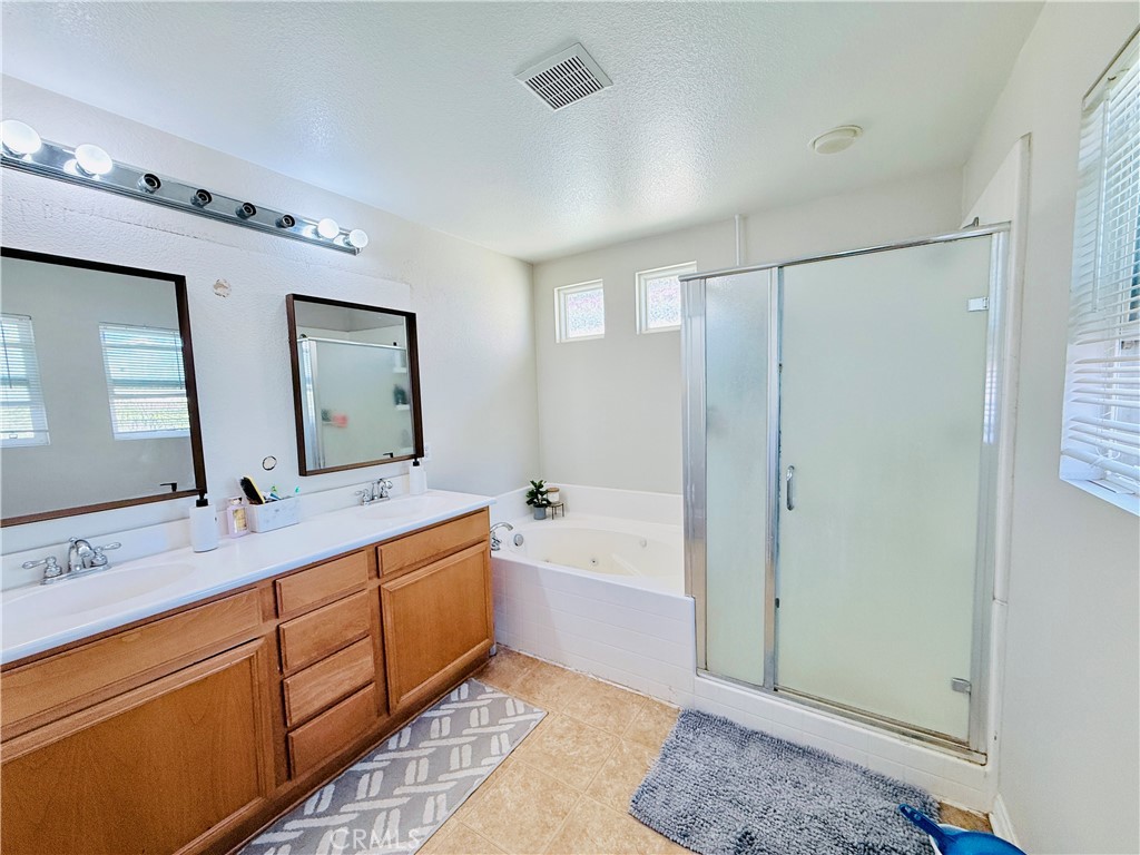 1652 Apollo Way Beaumont, CA 92223 - Photo 4 of 25 a bathroom with a double vanity sink mirror double and bathtub
