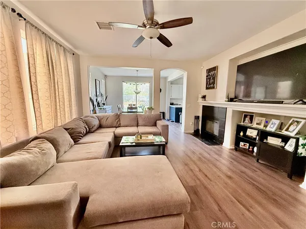 a living room with furniture a flat screen tv and a fireplace