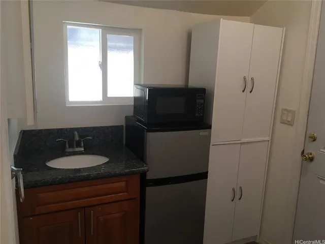 a bathroom with a granite countertop sink and a mirror