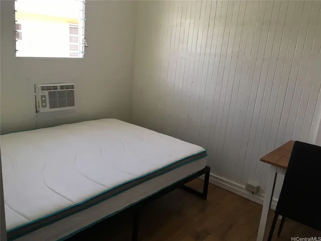 a bed sitting in a bedroom next to a window