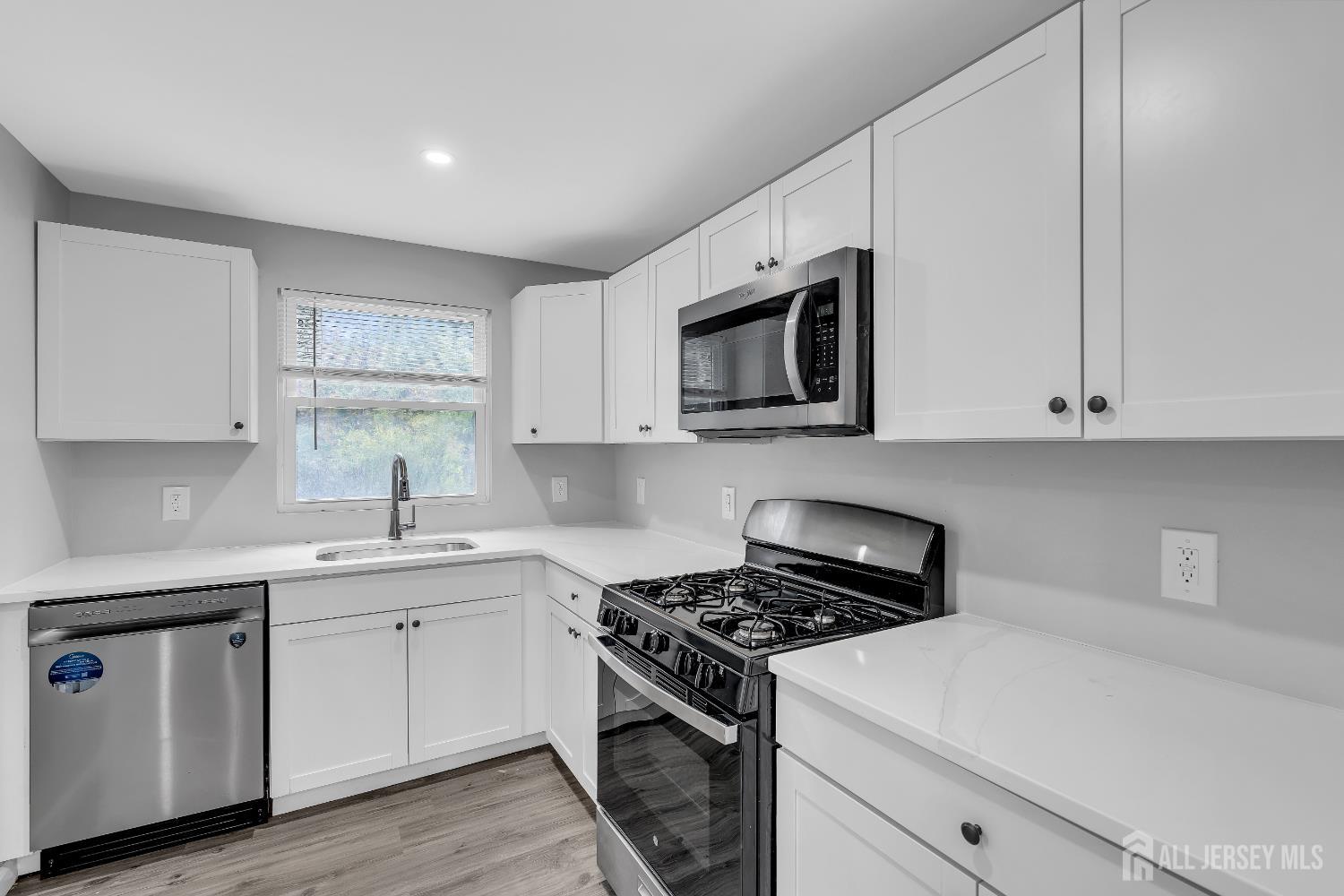 52 MacArthur Drive Edison, NJ 08837 - Photo 15 of 37 a kitchen with stainless steel appliances white cabinets and a stove top oven