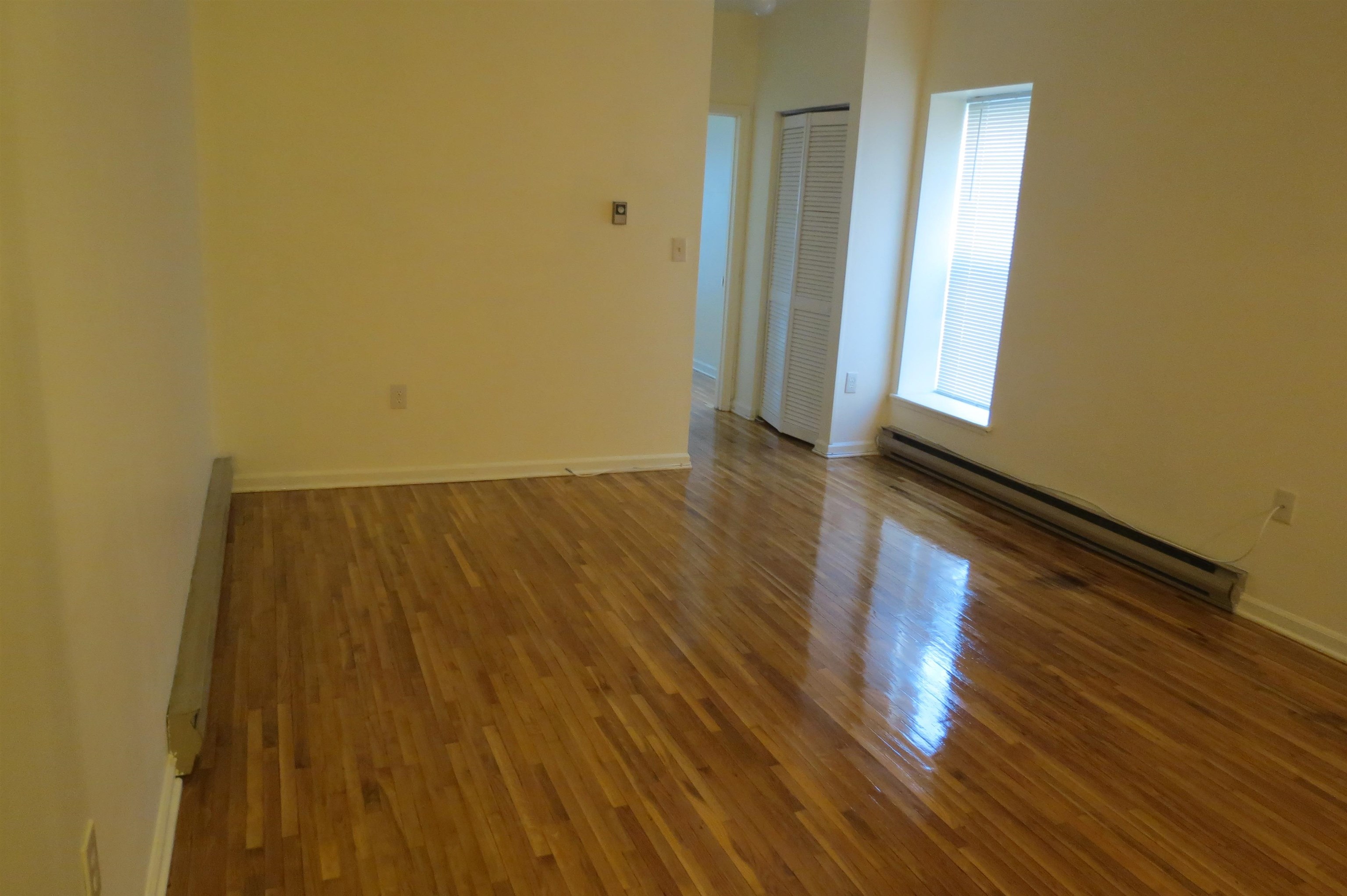 533 Monroe Street, Unit 1D Hoboken, NJ 07030 - Photo 5 of 13 a view of room with window and wooden floor