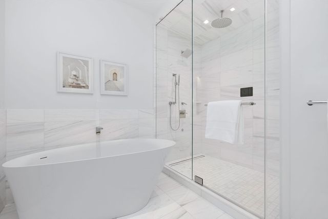 a white bath tub sitting next to a shower