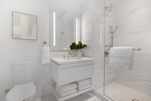 a bathroom with a sink a toilet and shower