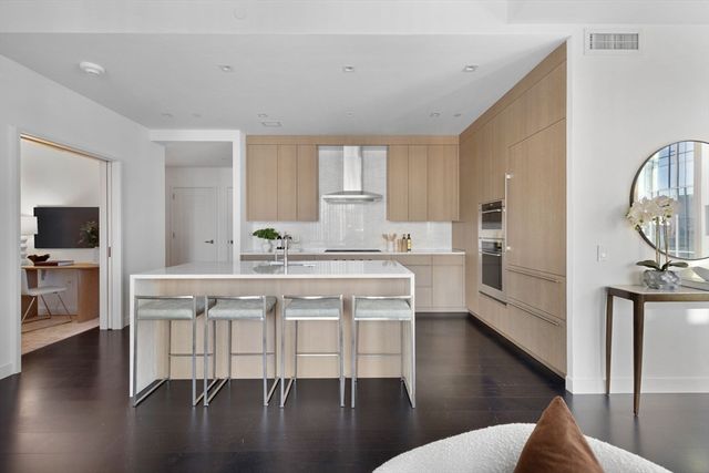 a kitchen with a table chairs refrigerator and cabinets