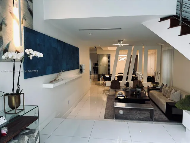 a large white kitchen with a large tub and couches a fireplace with wooden floor