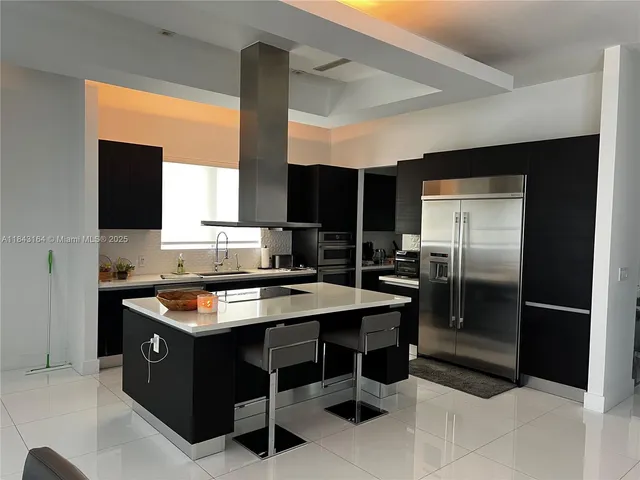 a kitchen with stainless steel appliances granite countertop a stove a refrigerator and a sink
