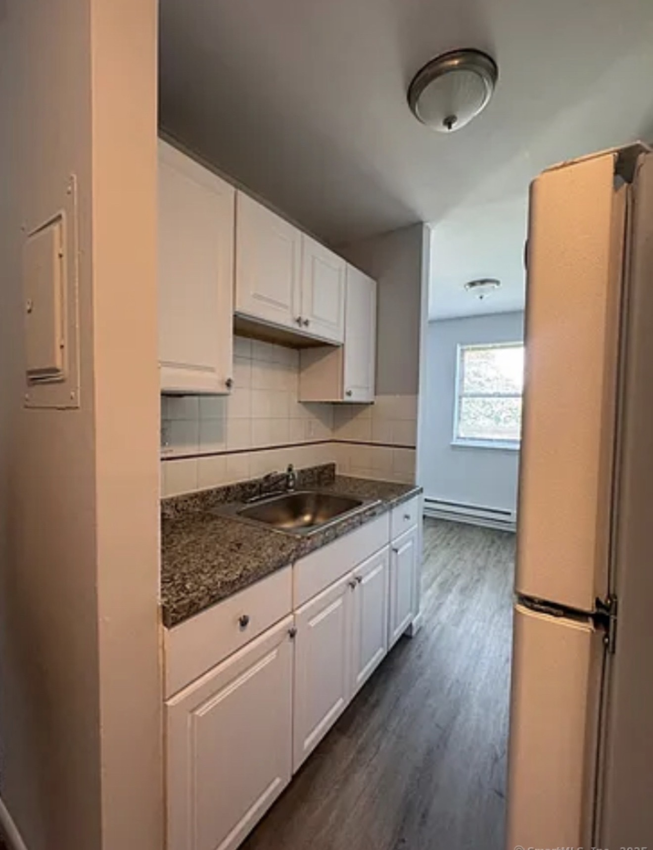 217 Hollister Avenue, Unit A8 Bridgeport, CT 06607 - Photo 1 of 1 a kitchen with a refrigerator a stove and wooden floor