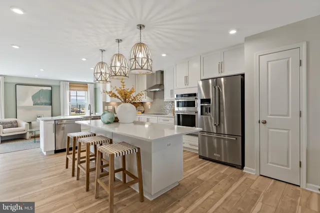 a kitchen with stainless steel appliances a dining table chairs stove and refrigerator