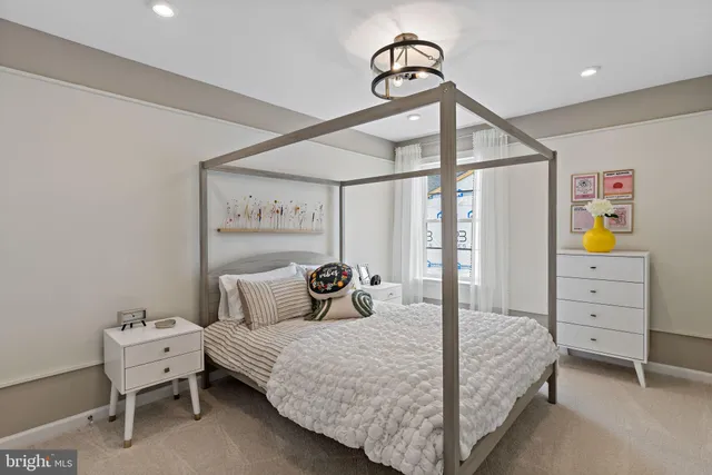 a bedroom with a bed a chandelier and a dresser