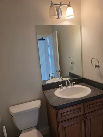 a bathroom with a sink a toilet and mirror
