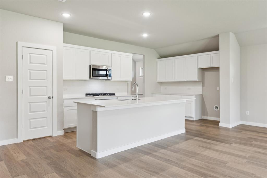 15213 Supreme Street Aledo, TX 76008 - Photo 6 of 32 a kitchen with a refrigerator and a stove top oven