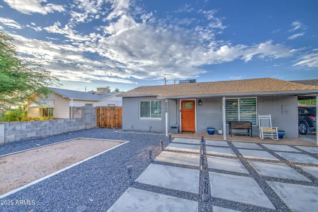 a front view of a house with a garden and trees