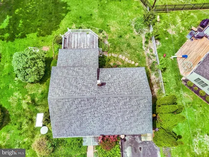 an aerial view of a house with a yard and large tree