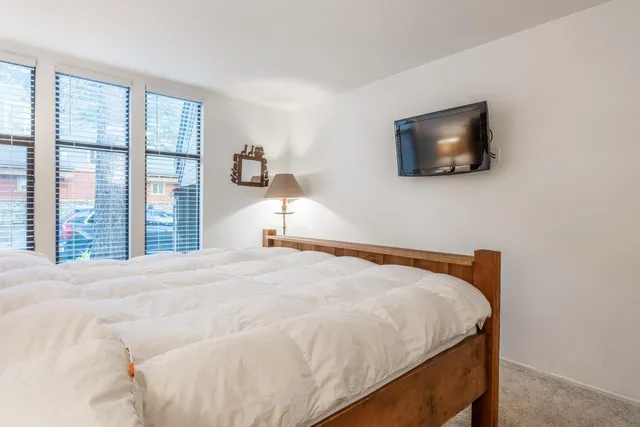 a bed sitting in a bedroom next to a window