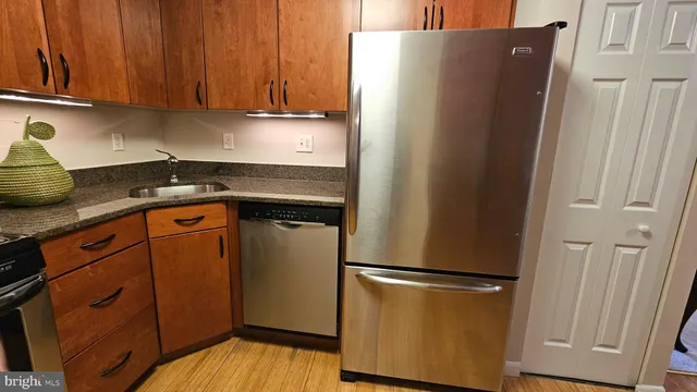 a kitchen with stainless steel appliances granite countertop a refrigerator and a sink