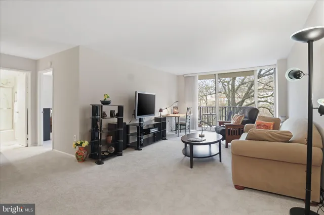 a living room with furniture a large window and a flat screen tv