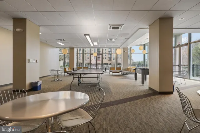 a dining room with furniture and a floor to ceiling window