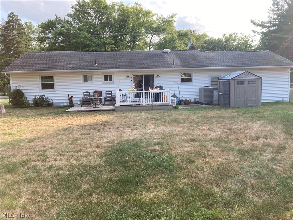 2547 Mayfair Road Akron, OH 44312 - Photo 2 of 50 Rear view of house with a deck, a storage unit, cooling unit, and a lawn