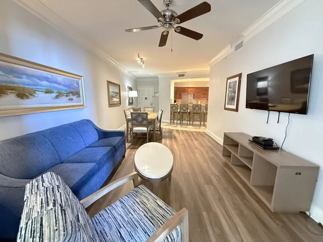 a living room with furniture a flat screen tv and kitchen view