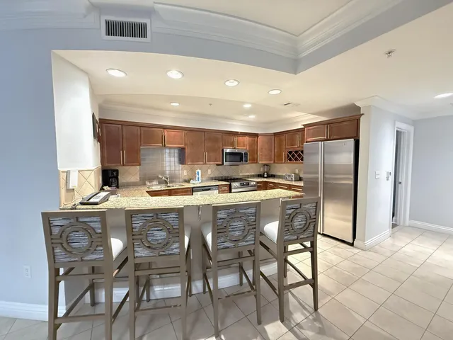 a kitchen with a dining table chairs refrigerator and cabinets