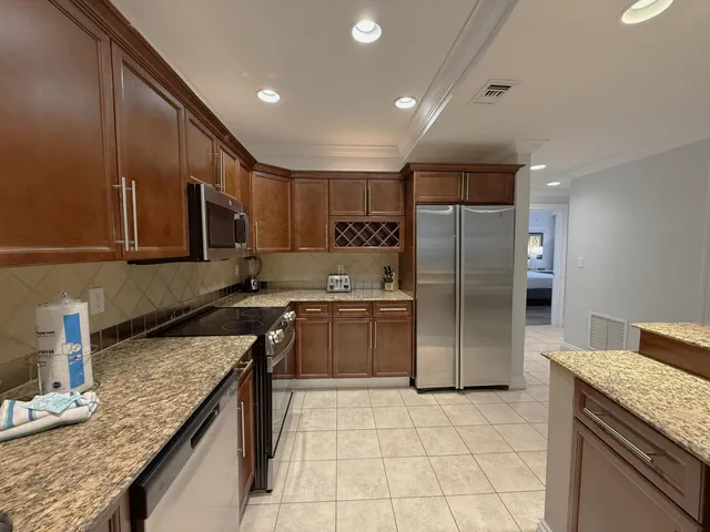 a kitchen with stainless steel appliances granite countertop a sink stove and refrigerator