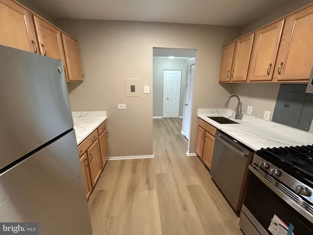 a kitchen with sink a refrigerator and a stove