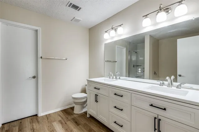 a bathroom with a double vanity sink toilet and a mirror
