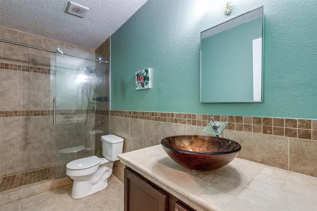 a bathroom with a sink a toilet and a mirror