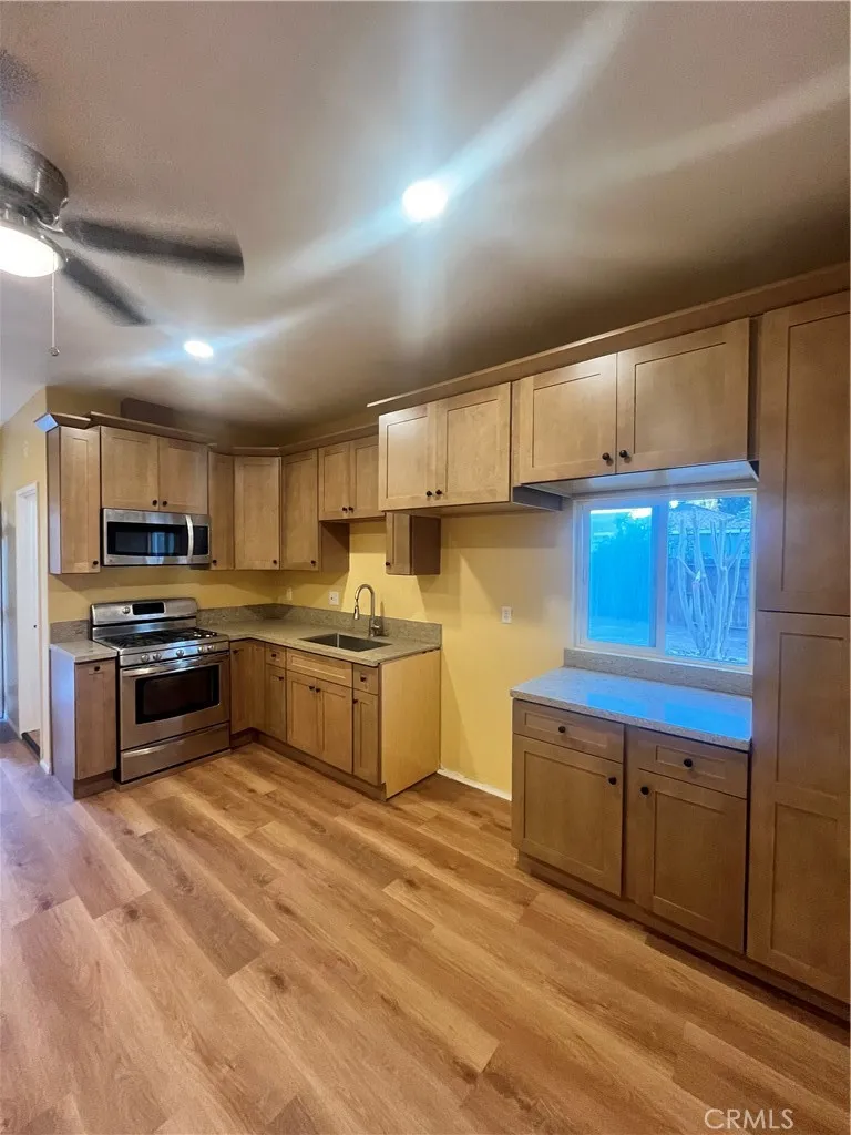 a kitchen with granite countertop a sink cabinets and stainless steel appliances