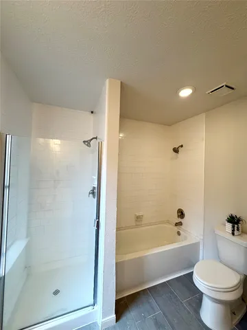 a bathroom with a bathtub toilet and a shower
