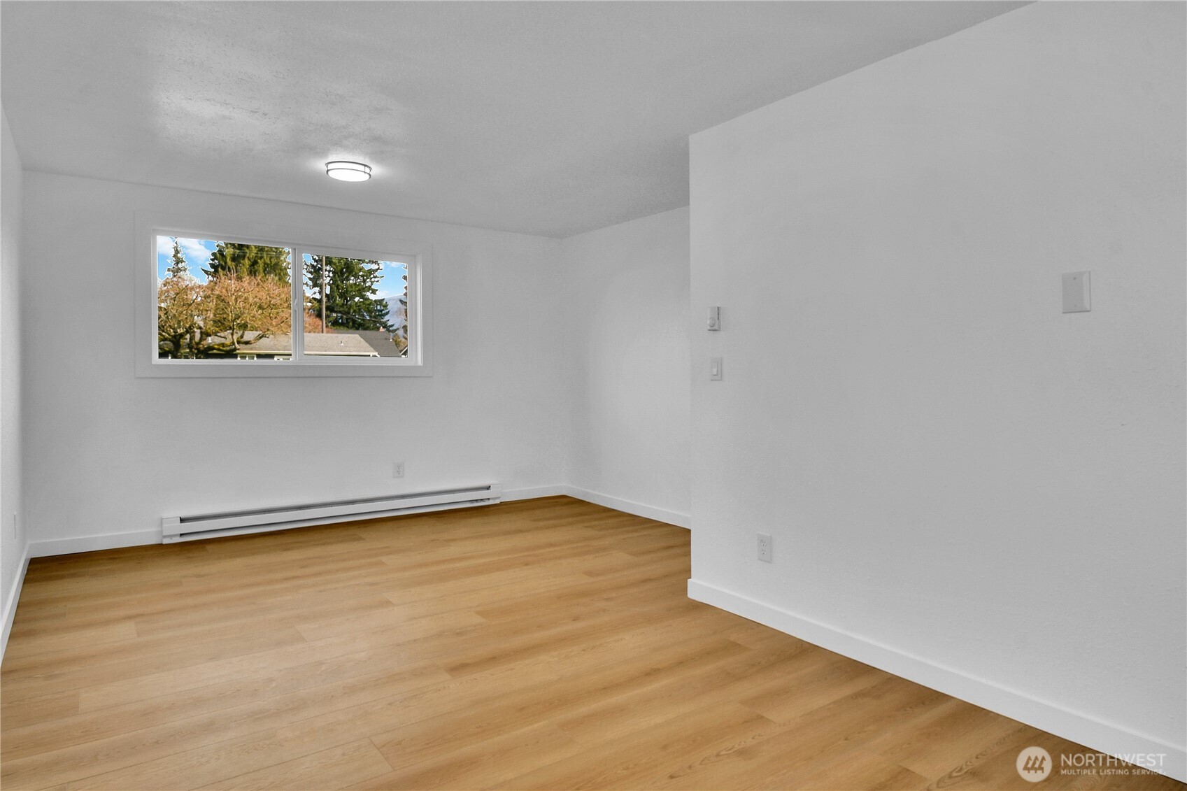 1006 Fidalgo Street Sedro-Woolley, WA 98284 - Photo 7 of 20 a view of a room with wooden floor and painting on the wall
