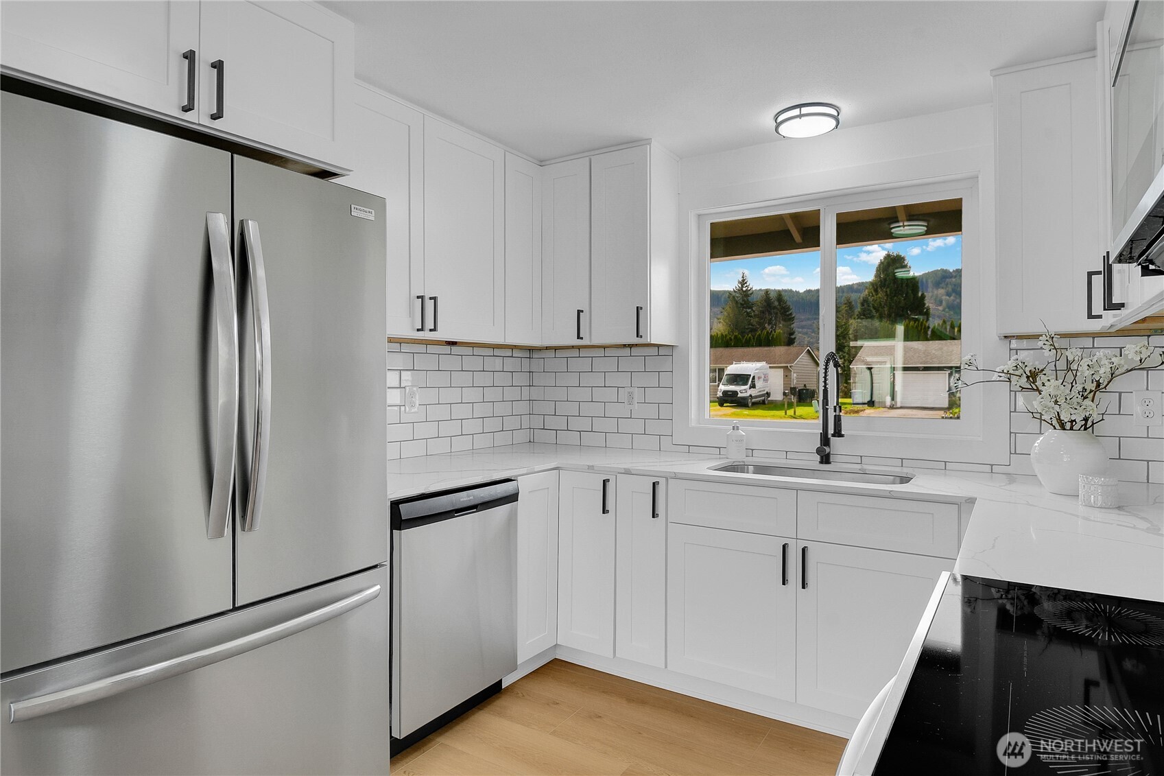 1006 Fidalgo Street Sedro-Woolley, WA 98284 - Photo 9 of 20 a kitchen with white cabinets and stainless steel appliances