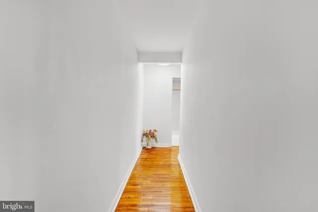 a walk in closet with wooden floor