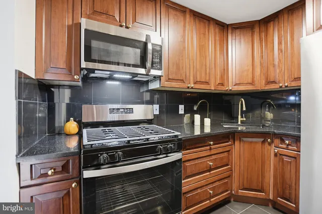 a kitchen with granite countertop a stove and a microwave