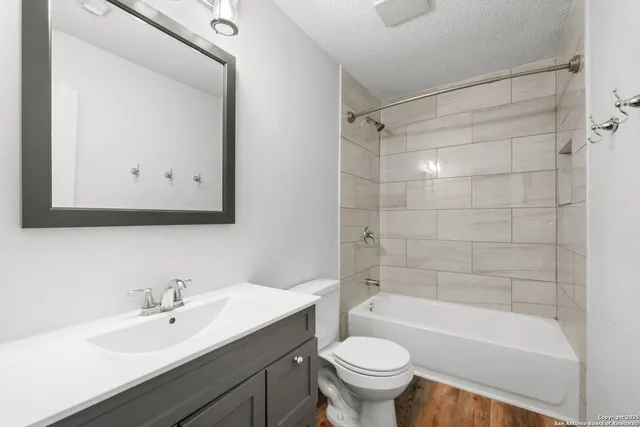 a bathroom with a bathtub shower sink mirror and toilet